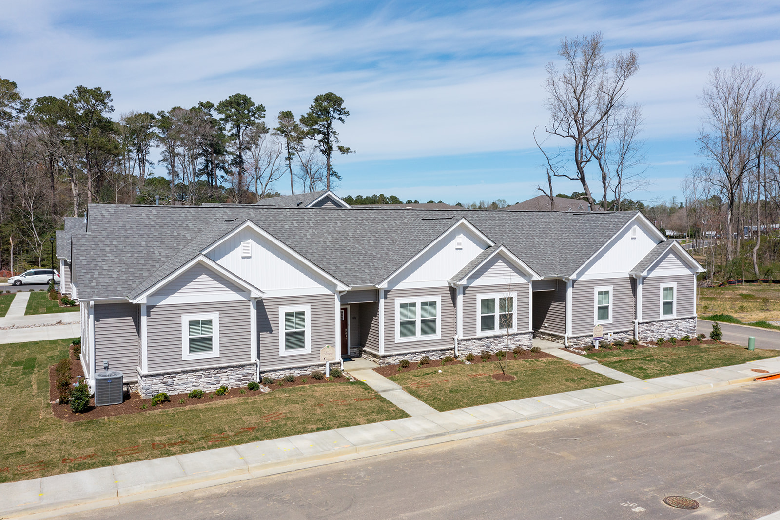 HALLSTEAD RESERVE MODELS Vineyards at Hallstead Reserve Exteriors. White and gray siding on the outside. Two forn doors are visible.