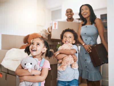 Moving, happy and real estate with family in new house for investment, property and future. Smile, boxes and purchase with children and parents for mortgage, excited and homeowner relocation